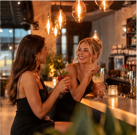 Zwei Gäste genießen Drinks an der Bar des FAME